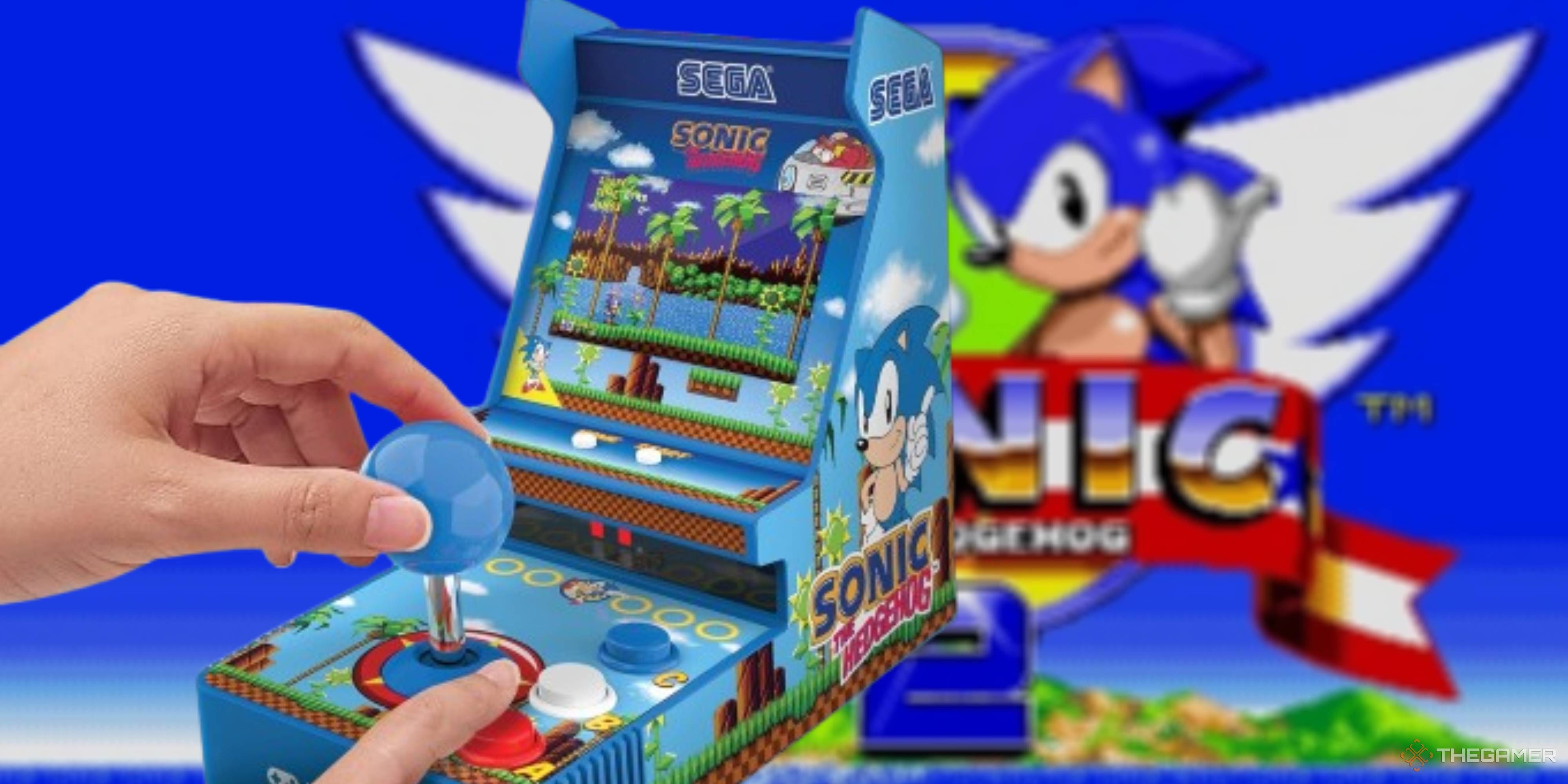 hands using a mini sonic arcade machine on a blurred sonic 2 title screen background.