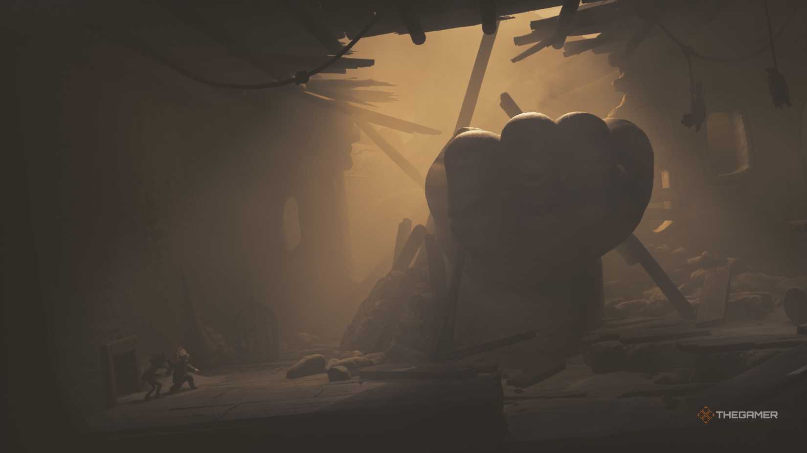 Alone and Low hiding from a large baby hand in Little Nightmares 3.