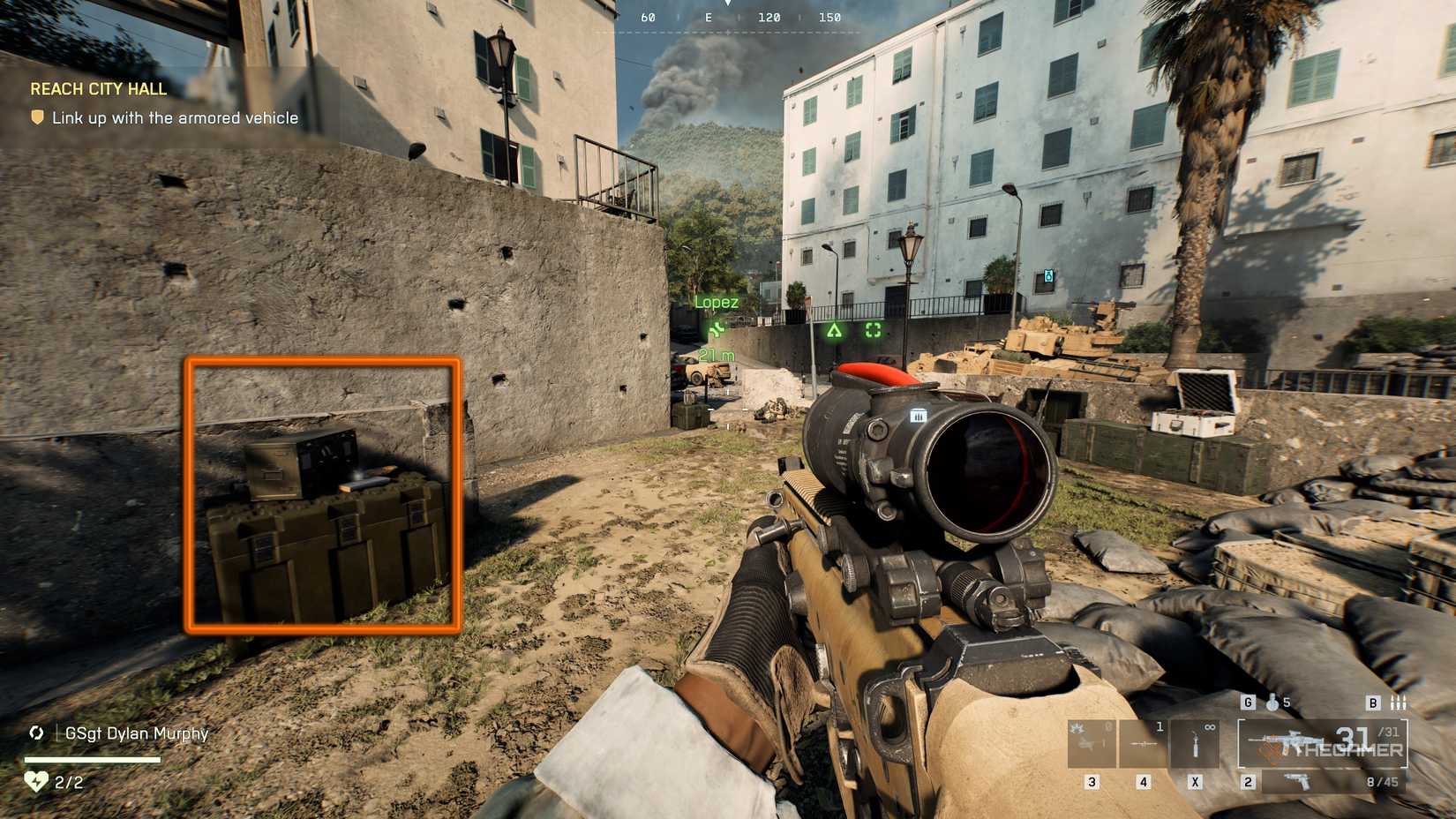 Battlefield 6 player performs at the parking lot to the streets of the city, with a military box to the left highlighted orange square.