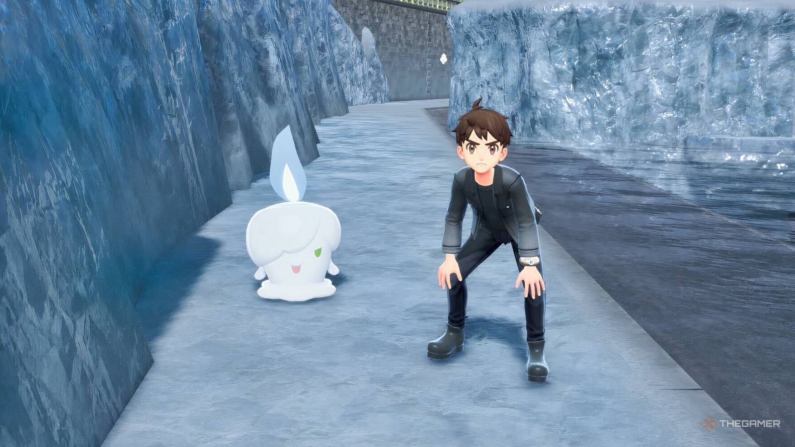 A crouched down trainer and a shiny alpha litwick looking angry in an icy environment.