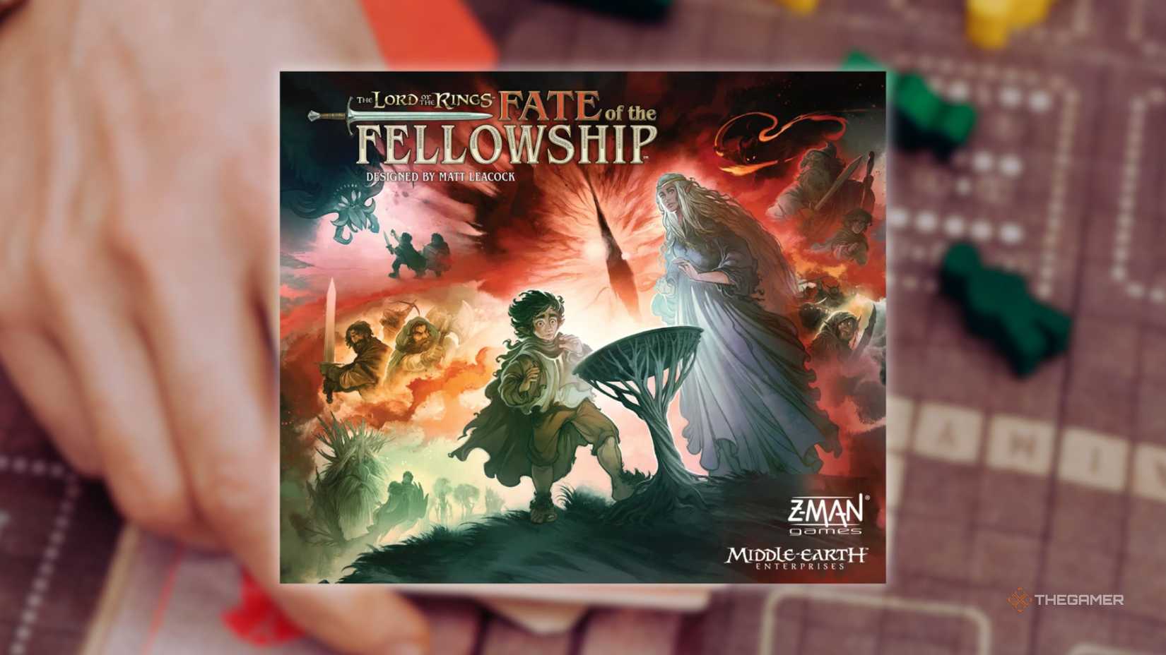 The cover of The Lord of the Rings Fate of the Fellowship in front of a hand playing a grid-based board game for the best board games of 2025.