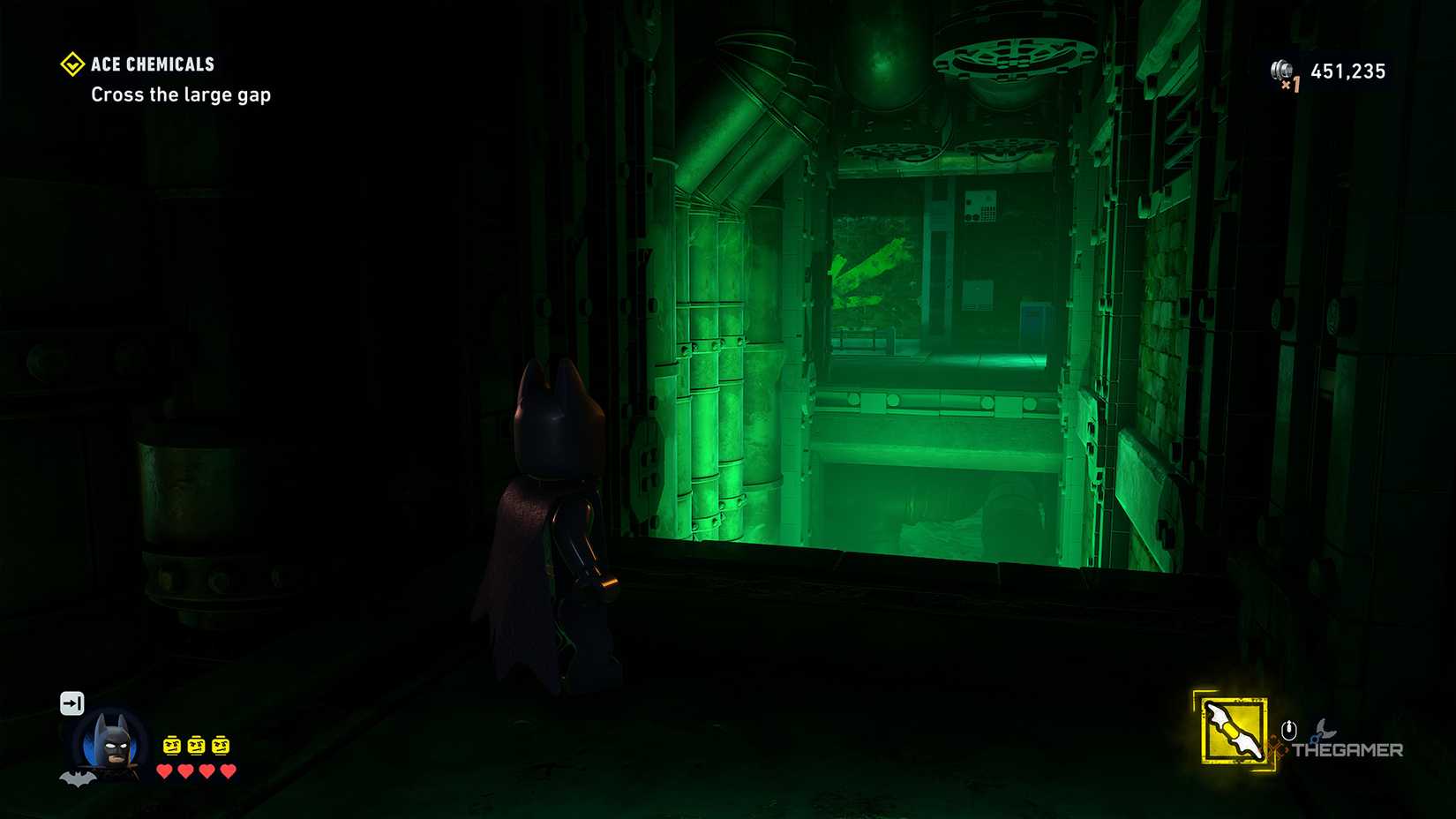 In LEGO Batman Legacy of the Dark Knight, Batman looks through a crack in a chemical plant.