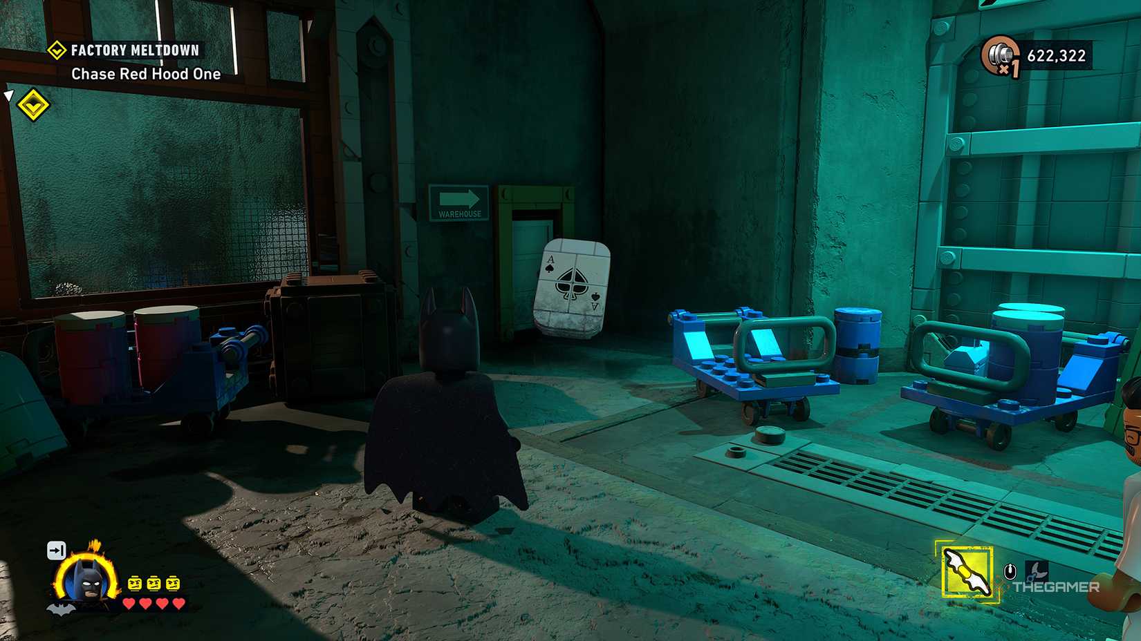 Batman looking at the Ace card leaning against the wall in LEGO Batman: The Dark Knight Legacy.