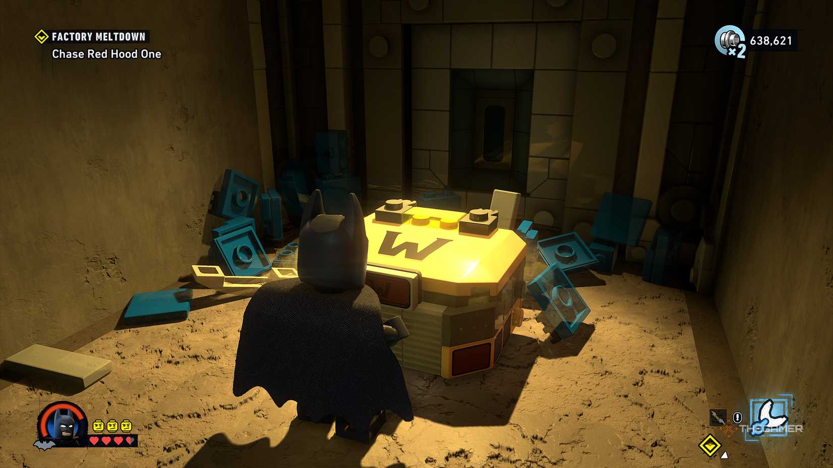 Surrounded by LEGO wreckage, Batman is opening the WayneTech cache in LEGO Batman: The Dark Knight's Legacy.