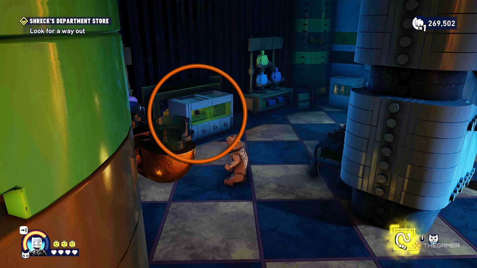 Catwoman on a checkered floor, with a square marked by an orange circle in Lego Batman Legacy of the Dark Knight.