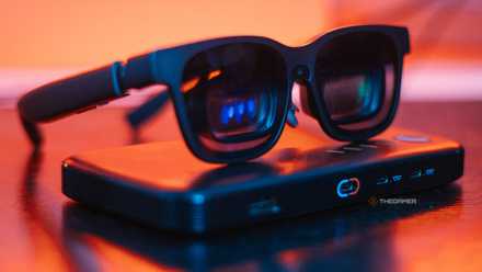 Viture Beast XR Glasses sitting on a Pro Mobile Dock on a desk with an orange light in the background.