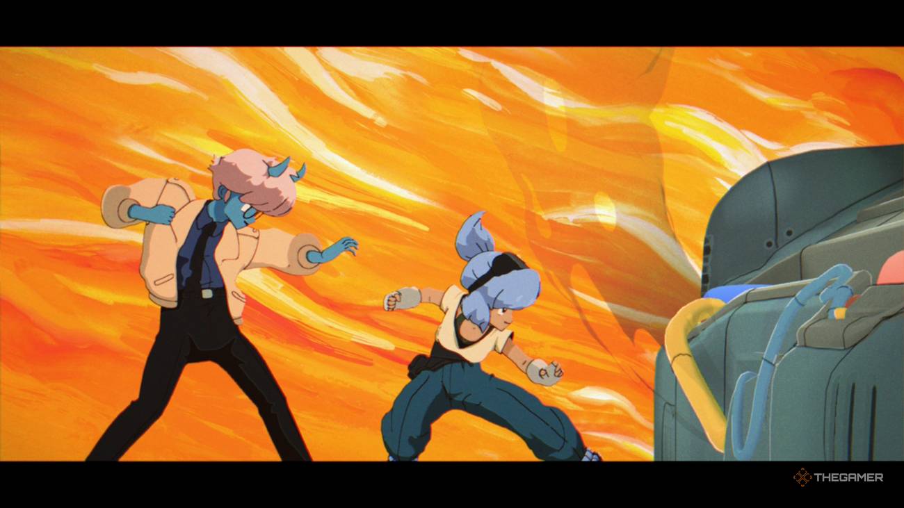 Maki and Omura posed to hit a button in Orbitals with a vibrant orange background behind them.