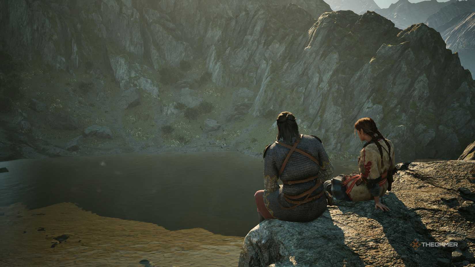 Coen and Anca sitting on a rock together looking out at a lake in The Blood of Dawnwalker.